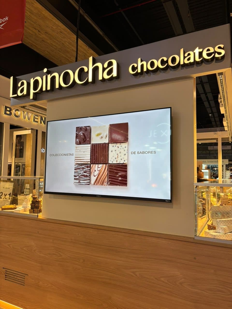 Isla La Pinocha en shopping con cartel iluminado y pantalla