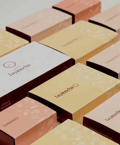 Cajas de bombones La Pinocha en tonos crema, rosa y dorado